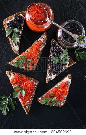 Red And Black Caviar In Small Silver Spoon On A Wood Background With Black Bread ,food Concept