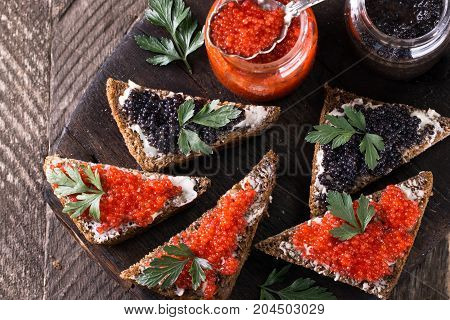 Red And Black Caviar In Small Silver Spoon On A Wood Background With Black Bread ,food Concept