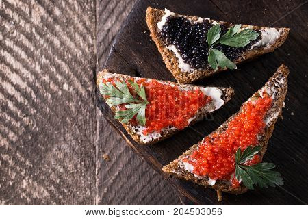 Red And Black Caviar In Small Silver Spoon On A Wood Background With Black Bread ,food Concept