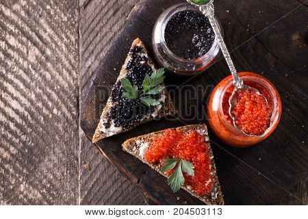 Red And Black Caviar In Small Silver Spoon On A Wood Background With Black Bread ,food Concept