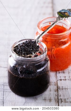Red And Black Caviar In Small Silver Spoon On A Wood Background With Black Bread ,food Concept