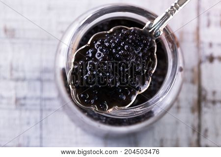 Red And Black Caviar In Small Silver Spoon On A Wood Background With Black Bread ,food Concept