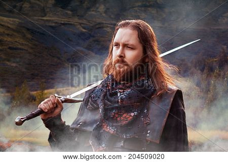 The bearded man knight. A guy in a medieval costume with a sword