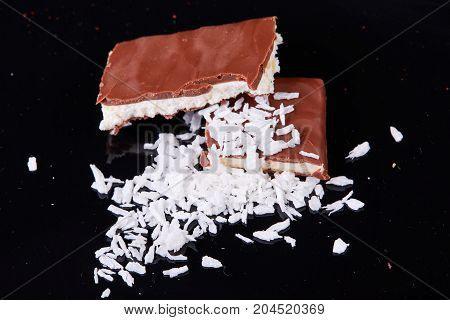 Homemade chocolate coconut bars with coconut flakes on top.