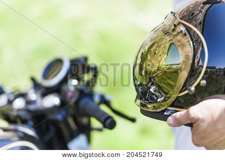 Cool reflection of custom made scrambler style cafe racer in the helmet