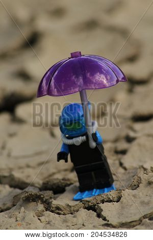 Figurine scuba diver with umbrella on parched ground/This is a detail of parched ground and figurine scuba diver with umbrella.