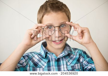 Handsome boy trying on big glasses. The concept of poor vision myopia eye strain education