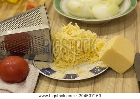 cheese grated on a grater on the table the ingredients