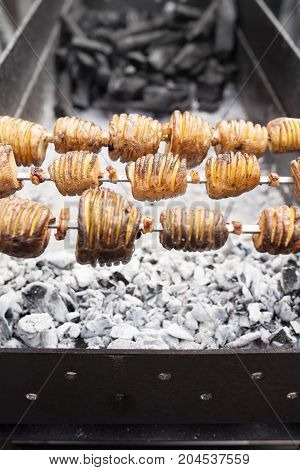 A Shish Kebab From Yellow Potatoes Put On A Skewer Is Fried On Blue Coals
