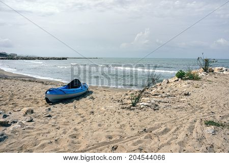 Albania. Beach on the Adriatic Sea in the Golem area a blue kayak boat stands on the shore