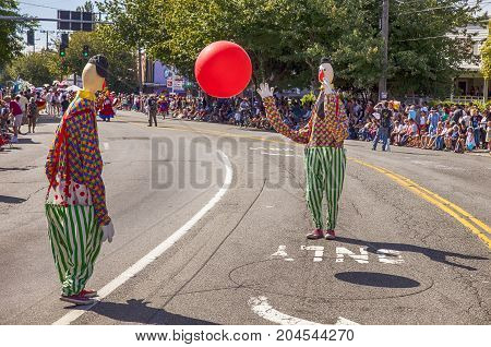 SEATTLE, USA - JUNE 22, 2013: Two clowns play catch with a red ball in the middle of the street during the Fremont Summer Solstice Parade in Seattle.