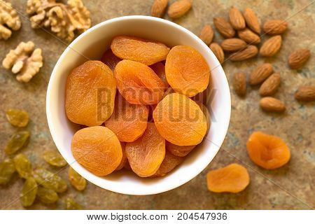 Dried apricots a healthy snack containing vitamins beta-carotene fiber antioxidants photographed overhead on slate with natural light (Selective Focus Focus on the apricots on the top)