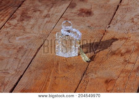 perfume bottle and pearls on a wooden background.pearl braclet. perfume