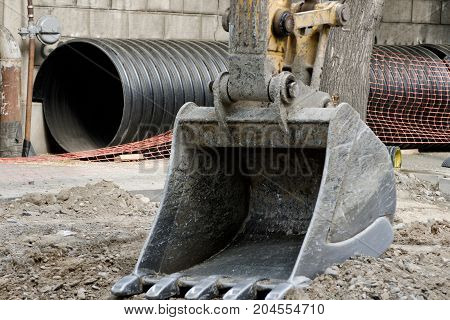 Large excavator bucket trumpet in the background. Replacement of pipes