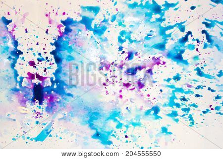 A spray of colors on a white sheet watercolor blue and magenta