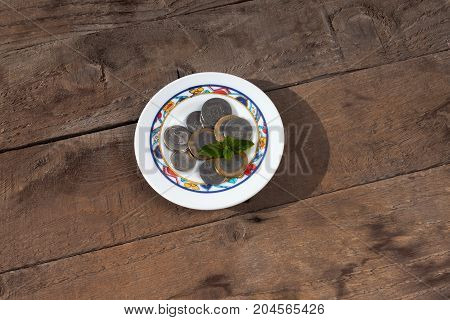 moroccan dirham in a small assiette on a wodden background.Moroccan money. argent