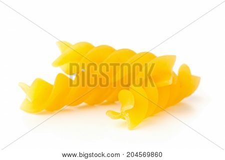 Closeup of raw uncooked dry fusilli or rotini pasta noodles with selective focus on white background