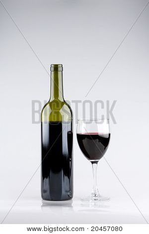 Glas rode wijn met groene fles