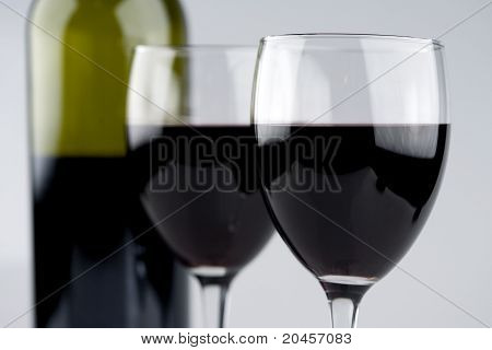 Twee glas rode wijn met groene fles