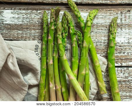 Green raw asparagus on rustic wooden background