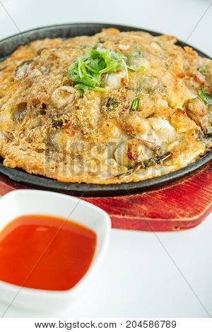 Oyster omelette serve on hot pan with sauce