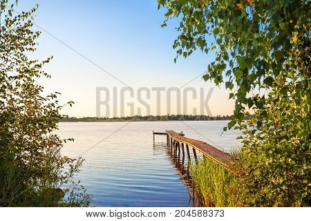 rural summer landscape with river bridge. pier on lake