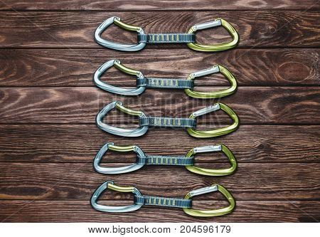 Climbing quickdraws on a wooden background top view.