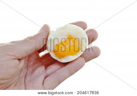 boiled egg half cut with creamy yolk holding on hand in white background
