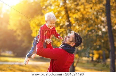 happy family father and baby son playing and laughing on autumn walk