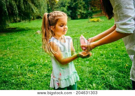 mother with daughter play with holi paints in city park