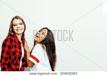 best friends teenage girls together having fun, posing emotional on white background, besties happy smiling, lifestyle people concept, blond and brunette multi nations close up