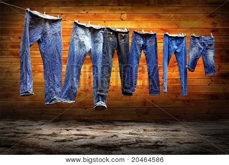 กางเกงยีนส์บนราวตากผ้าให้แห้งบนพื้น grunge