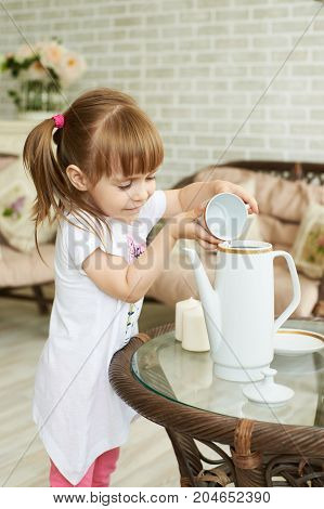 Young smiling cute girl pouring water in jar