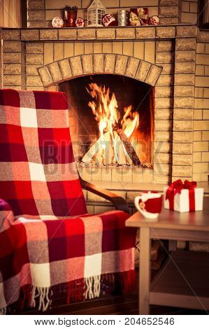 Сheckered armchair near fireplace. Winter holiday concept