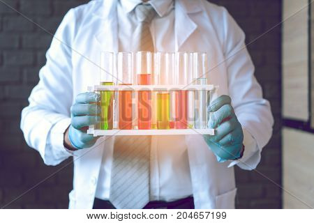 Scientist man with glasses working reserch and conducts experiments by synthesising compounds in laboratory and the test tube