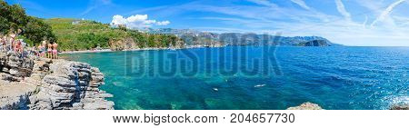 BUDVA MONTENEGRO - SEPTEMBER 7 2017: Unknown people admire panoramic view of Budva coast (Mogren beach Budva Old Town Sveti Nikola Island) from high cliff near beach Montenegro