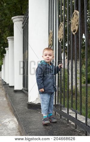 Young boy. Cute blond in town. Blue dress