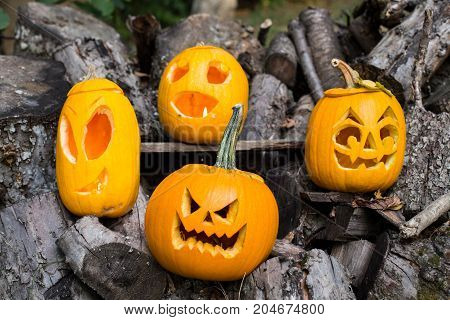 Halloween Themes. Composition Of Four Carved Halloween Pumpkins On Wooden Background. Pumpkins With