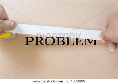 hiding problem concept with hand holding tape to cover up problem