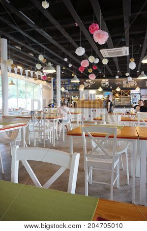 Wooden tables with white chairs and decoration on the ceiling in the Rusalka restaurant on August 2017 in Poznan Poland