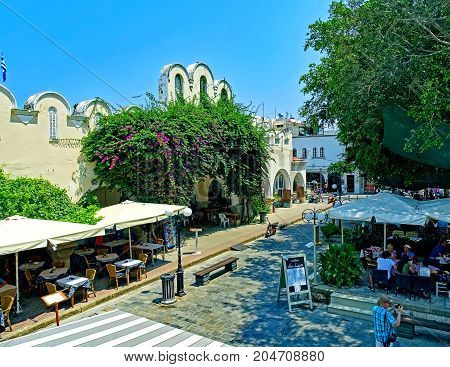 Kos, Greece - July 31, 2015: People enjoying a sunny summer day in outdoor restaurants at the market hall in the old town of Kos town on the island of Kos in Greece.