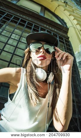 A beautiful young Hip Hop Rapper girl with Headphones in a urban environment.