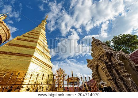 Wat Phra That Cho Hae Buddhism Temple with golden pagoda on blue sky background. Places worship of buddhists and attractions famous religion at Phrae Province Thailand