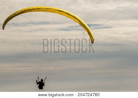 A para-glider up in the sky during a fly surrounded by the clouds