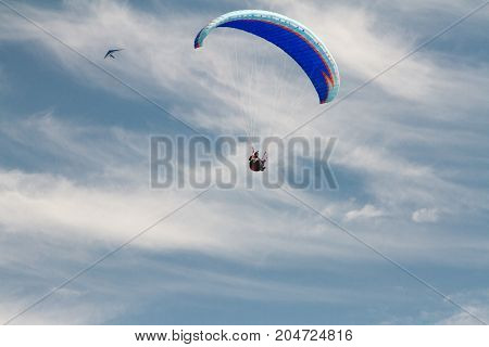 A para-glider up in the sky during a fly surrounded by the clouds