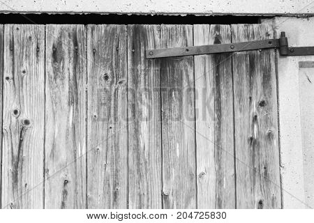 Old barn door with a rusty metal hinge in my back yard