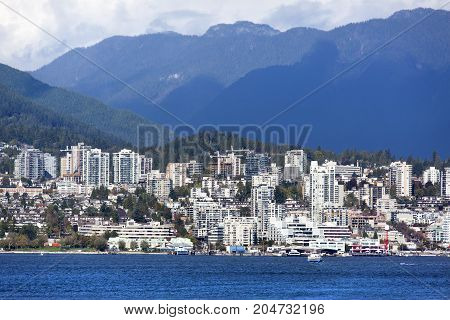 Modern buildin skyline of West Vancouver district surrounded by mountains (Vancouver British Columbia).