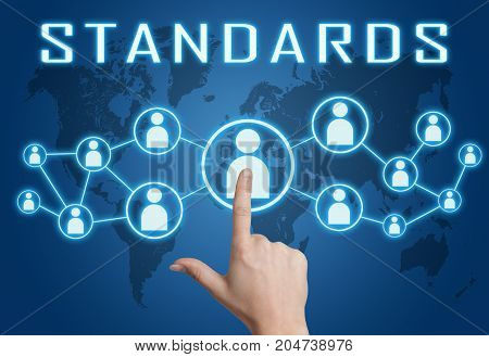 Standards - text concept with hand pressing social icons on blue world map background.