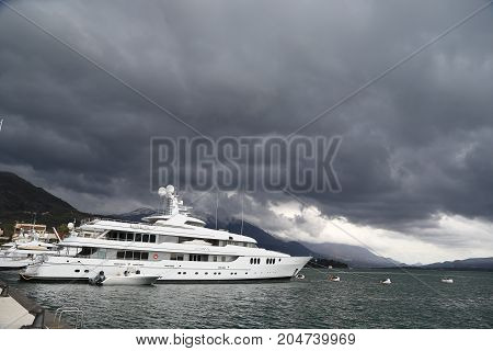 july 2017 Montenegro. Luxury yacht at the pier of the marina in Porto Montenegro with cloudy dark sky