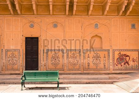 JAIPUR RAJASTHAN INDIA - MARCH 11 2016: Horizontal picture of green bench with painted wall inside of Nahargarh in Jaipur known as pink city of Rajasthan in India.